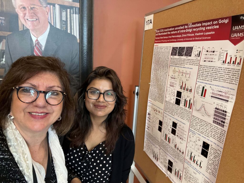Dr. Bellido and a student posing by a research poster