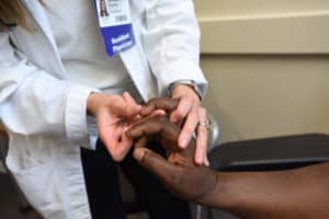 Resident examining a patient’s finger