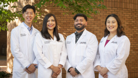 Group photo of PGY-1 Residents. They are posed outside and wearing white coats