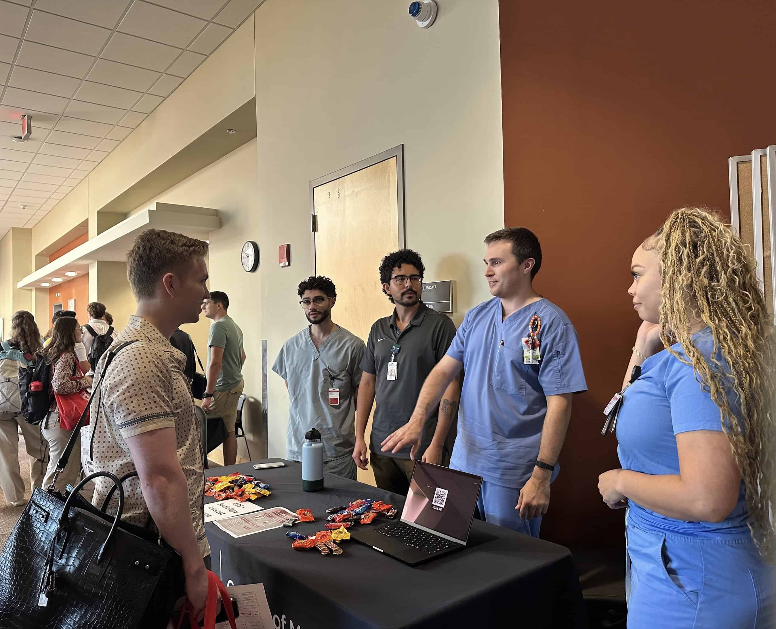 Students standing at a table.