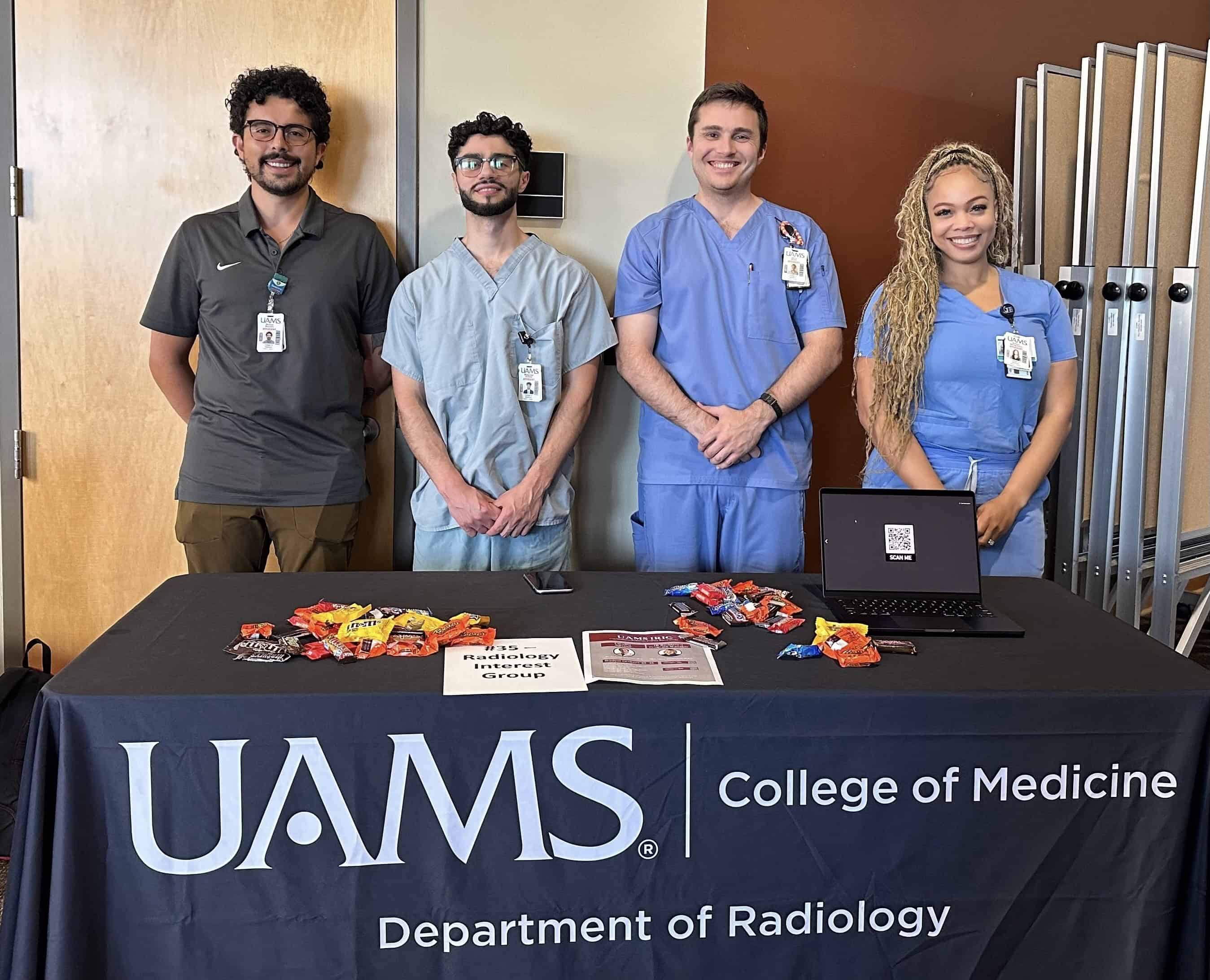 Students standing at a table.