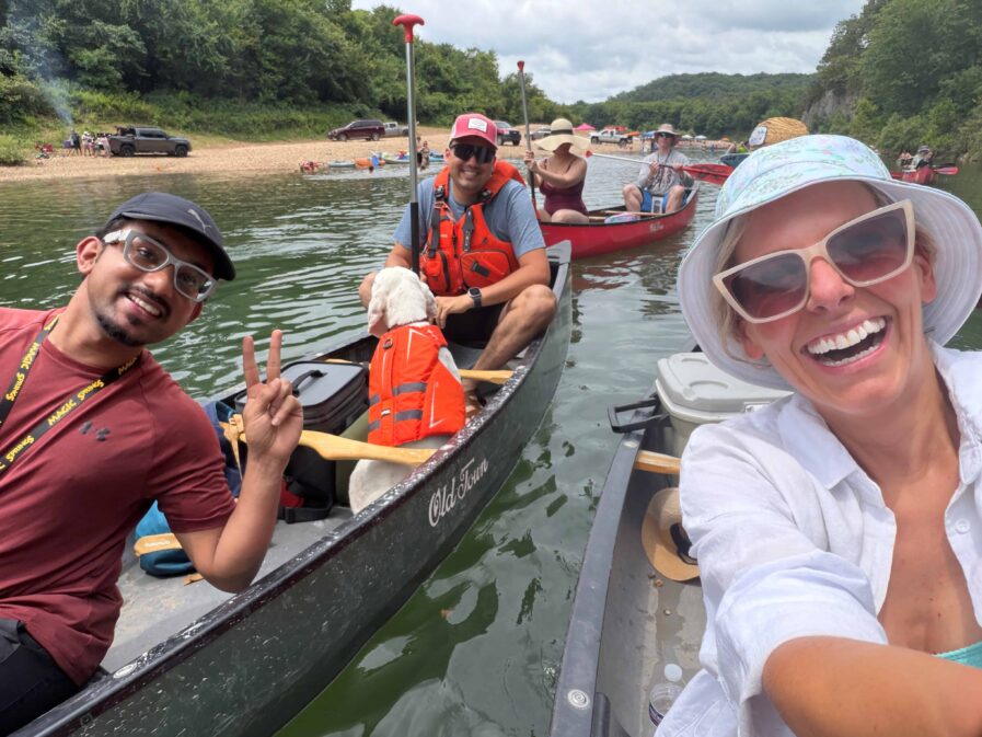 Photo of residents and a dog floating in canoes.