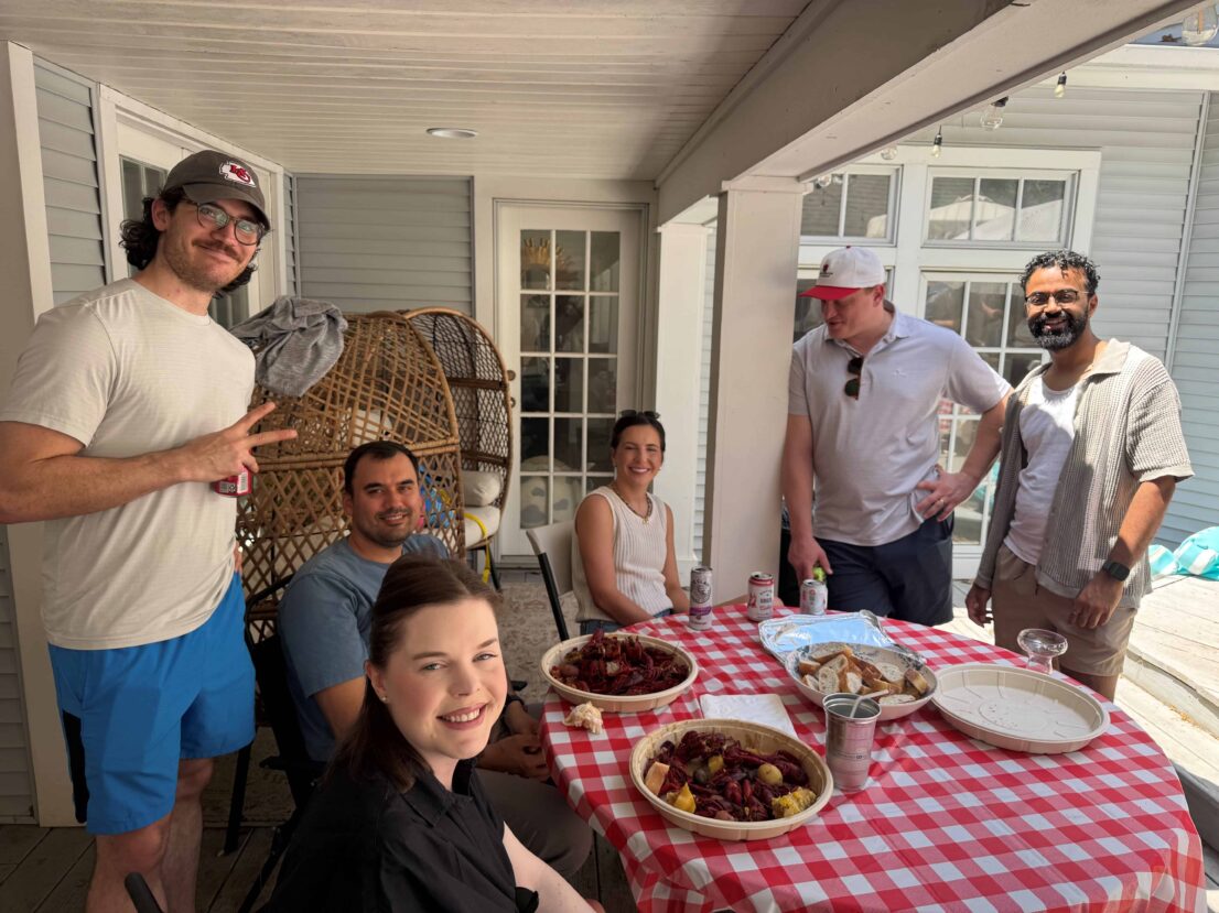 People sitting around a table outside.
