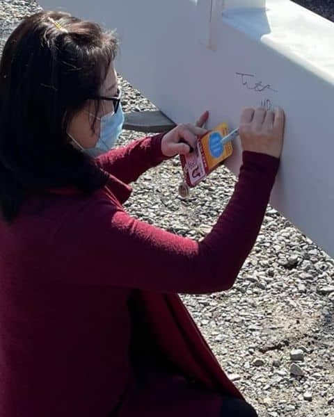 Dr. Fen Xia signs final beam for new Radiation Oncology building.