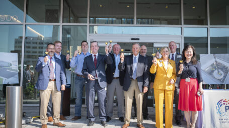 Representatives from UAMS, Arkansas Children's, Baptist Health, and Proton International ring small bells to celebrate the opening of the Proton Center of Arkansas
