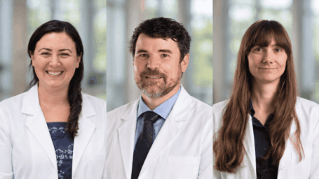 three medical researchers in white lab coats