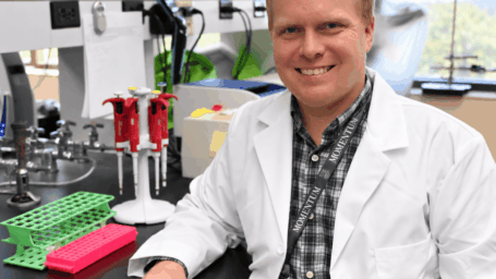 smiling male scientist in a bright laboratory
