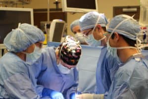 Faculty and resident surgeons performing surgery.