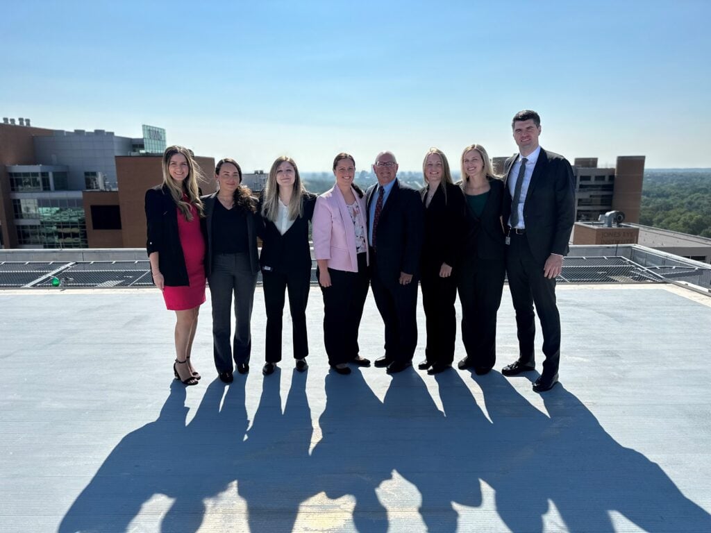 group of residents and faculty members posing on the helicopter pad above the UAMS Medical Center