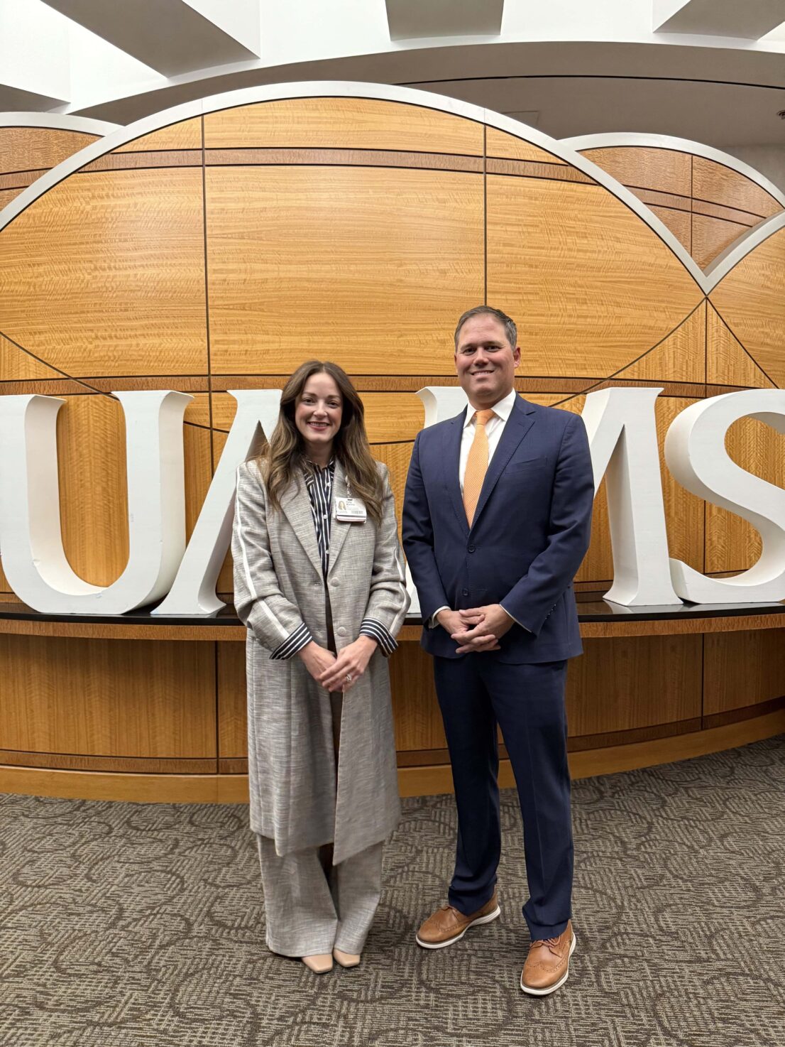 two people standing in front of a UAMS sign