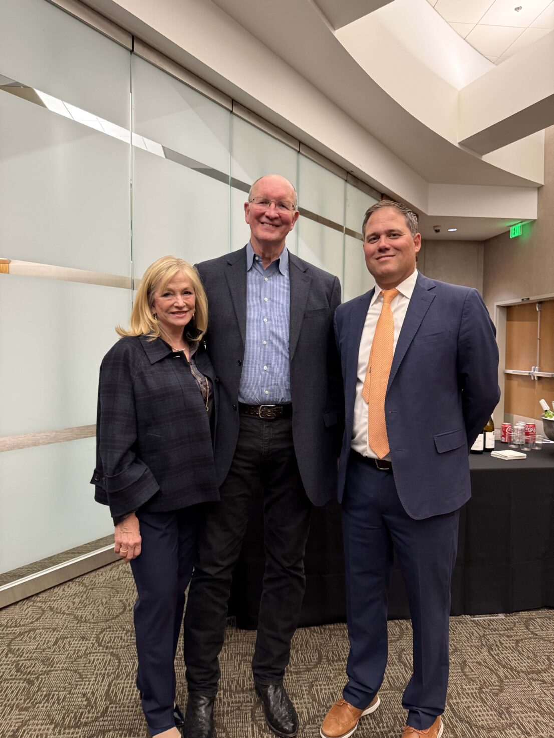 two people posing with the guest speaker in the lobby