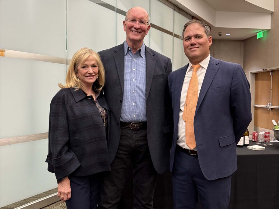 two people posing with the guest speaker in the lobby