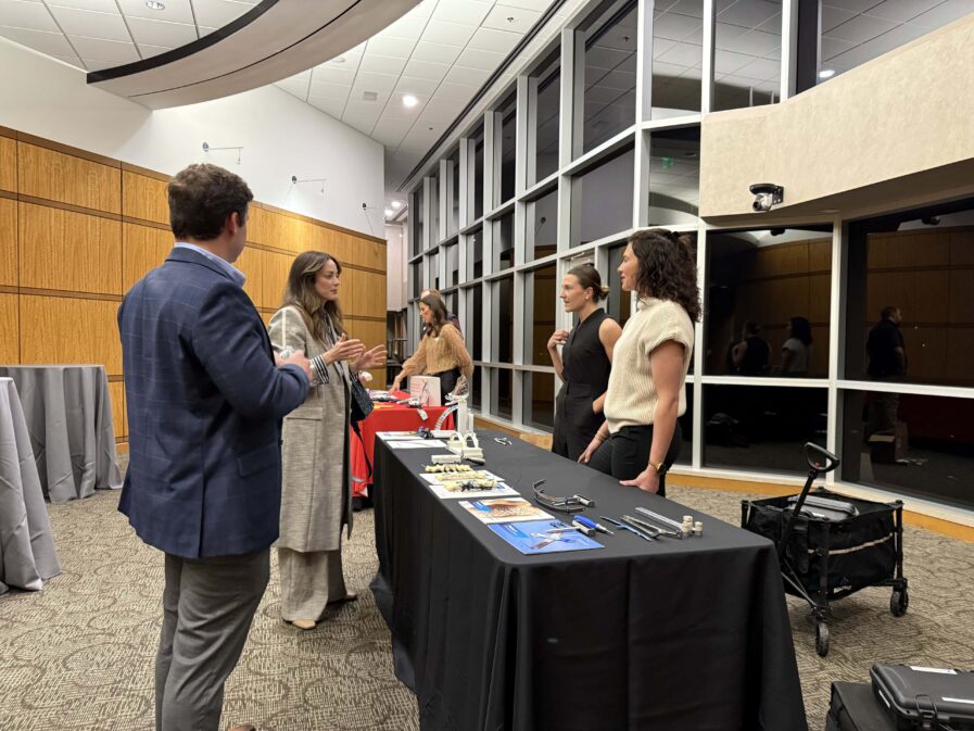 people talking at a display table in the lobby