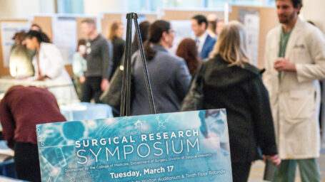 Attendees mingle near research poster boards during a previous UAMS Surgical Research Symposium, sponsored by the College of Medicine Department of Surgery, Division of Surgical Research.