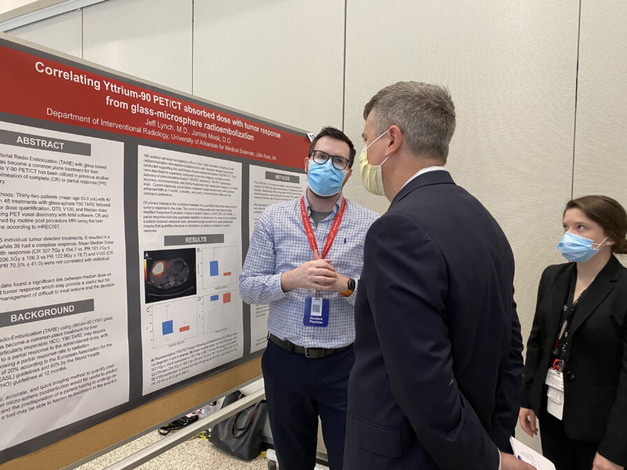 Researcher explaining poster to a faculty member