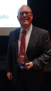 Ron Robertson, M.D., holding award