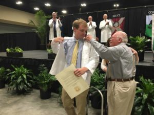 Jackson Weaver receives his white coat from his grandfather