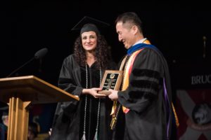 Student presenting plaque to faculty member