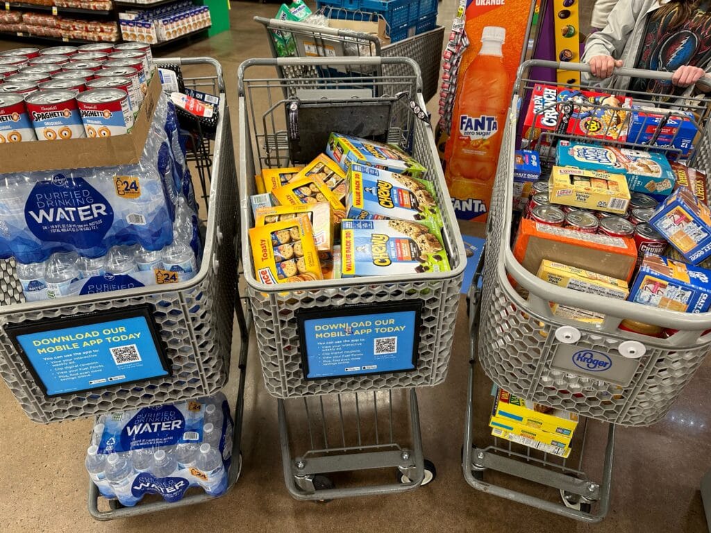 Three shopping carts filled with food items