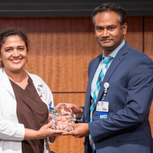 Manisha Singh and Dinesh Edem with award on stage