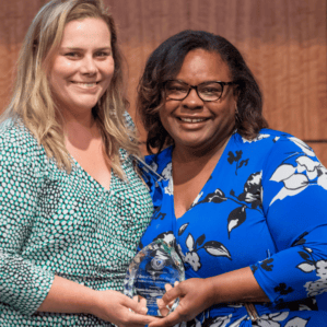 Sarah Sobik and Chenia Eubanks with award on stage