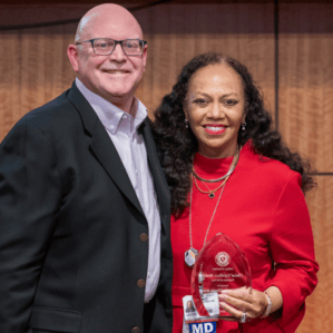 Ron Robertson and Ronda Henry-Tillman with award on stage