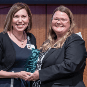 Nikki Edge and Lorraine McKelvey with award on stage