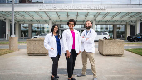 Three College of Medicine students pose in front of the UAMS Medical Center