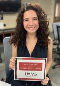 Photo of med student in 2025 holding "First day of Medical School" sign