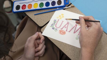 An M1 student participates in a paiting activity as part of Welcome Week 2025 to promote student wellness.